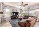 Cozy living room featuring a plush sectional sofa, ceiling fan, and large windows at 3256 E Maplewood St, Gilbert, AZ 85297