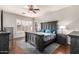 Spacious main bedroom with a dark wood bed frame, decorative ceiling fan and ample natural light at 3256 E Maplewood St, Gilbert, AZ 85297