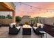 The backyard patio has furniture arranged around a fire pit and string lights overhead at 3256 E Maplewood St, Gilbert, AZ 85297