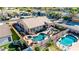 Aerial view of a backyard featuring a pool, spa, covered patio, outdoor kitchen, and lush landscaping, perfect for relaxation and entertaining at 3256 E Maplewood St, Gilbert, AZ 85297