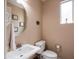 Cozy half bathroom features a white vanity, round mirror, and ample natural light from the window at 3261 S Sunland Dr, Chandler, AZ 85248