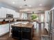 Open kitchen with white cabinets, granite countertops, and an island with breakfast bar seating at 3261 S Sunland Dr, Chandler, AZ 85248