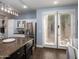Open-concept kitchen featuring a central island, stainless steel refrigerator, and access to the outdoor patio at 3261 S Sunland Dr, Chandler, AZ 85248