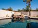 Stunning backyard pool featuring a rock waterfall, a lush palm tree, and privacy walls at 3261 S Sunland Dr, Chandler, AZ 85248