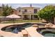 Fenced backyard features a pool, spa, rock waterfall, covered patio, and grass at 3261 S Sunland Dr, Chandler, AZ 85248
