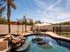Backyard pool and spa feature a rock waterfall, mature landscaping, and lounge chairs at 3261 S Sunland Dr, Chandler, AZ 85248