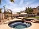 Sparkling pool and spa with rock features, bordered by mature landscaping, and lounge chairs at 3261 S Sunland Dr, Chandler, AZ 85248
