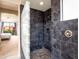 Modern shower with dark tile and glass block wall, offering both style and natural light at 3261 S Sunland Dr, Chandler, AZ 85248