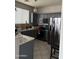 A functional kitchen featuring stainless steel appliances, tile floors, and ample storage space at 3825 S 60 Dr, Phoenix, AZ 85043
