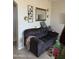 Comfortable living room with a dark gray couch, tile floors, decorative wall art and a large mirror at 3825 S 60 Dr, Phoenix, AZ 85043