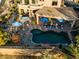 A high angle of the backyard featuring a pool, a jacuzzi, and covered patio with lounge chairs, complemented by lush landscaping at 3830 N Red Sky Cir, Mesa, AZ 85207