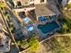 Aerial view of the backyard featuring a pool, jacuzzi, covered patio with lounge chairs, and lush landscaping at 3830 N Red Sky Cir, Mesa, AZ 85207