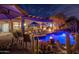 Beautiful backyard oasis with a covered patio, swimming pool, and lush desert landscaping, perfect for outdoor entertaining at 3830 N Red Sky Cir, Mesa, AZ 85207