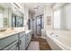 Bright bathroom featuring double sinks, a glass-enclosed shower, and a soaking tub at 3830 N Red Sky Cir, Mesa, AZ 85207