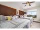 Well-lit bedroom with two beds, ceiling fan, and a view of the outside landscape at 3830 N Red Sky Cir, Mesa, AZ 85207