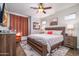 Bedroom with a wooden bed frame, ceiling fan, sitting chair and natural lighting at 3830 N Red Sky Cir, Mesa, AZ 85207