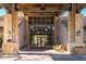 Beautiful clubhouse entrance with stone pillars, lush landscaping, and a welcoming covered entryway at 3830 N Red Sky Cir, Mesa, AZ 85207