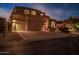 Charming exterior featuring a three-car garage and well-maintained landscaping, bathed in the soft glow of evening at 3830 N Red Sky Cir, Mesa, AZ 85207