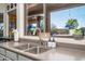 Bright kitchen sink with a window view of the backyard pool and outdoor seating area at 3830 N Red Sky Cir, Mesa, AZ 85207
