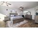 Spacious main bedroom with natural light, featuring a stylish bed set, wood-look floors, and ceiling fans at 3830 N Red Sky Cir, Mesa, AZ 85207