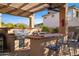 Outdoor kitchen with built-in grill, bar seating, and brick accents at 3830 N Red Sky Cir, Mesa, AZ 85207