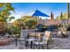 Inviting patio area with seating, desert landscaping, and shade umbrella at 3830 N Red Sky Cir, Mesa, AZ 85207