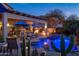 Stunning backyard pool and patio area with outdoor kitchen and desert landscaping at twilight at 3830 N Red Sky Cir, Mesa, AZ 85207