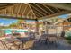 Covered poolside patio with tables and chairs overlooking the community pool and lush landscaping at 3830 N Red Sky Cir, Mesa, AZ 85207