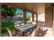 Inviting covered back patio with an outdoor table and chairs overlooking a refreshing pool and lush backyard at 4030 E Prickly Pear Trl, Phoenix, AZ 85050