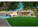 Large backyard featuring green turf, a refreshing pool, and covered patio, perfect for outdoor living at 4030 E Prickly Pear Trl, Phoenix, AZ 85050