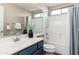Well-lit bathroom featuring a vanity with blue cabinets, shower, and a mirror that spans the length of the counter at 4030 E Prickly Pear Trl, Phoenix, AZ 85050