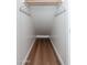 Narrow closet area featuring wooden floors, rod, and hooks for added storage space at 4030 E Prickly Pear Trl, Phoenix, AZ 85050