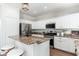 Modern kitchen boasts white cabinets, stainless steel appliances, and center island at 4030 E Prickly Pear Trl, Phoenix, AZ 85050
