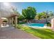 Backyard featuring a pristine in-ground pool, putting green, covered patio, and lush, well-maintained landscaping at 4030 E Prickly Pear Trl, Phoenix, AZ 85050