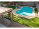 Aerial view of a backyard with a sparkling pool, putting green and covered patio at 4030 E Prickly Pear Trl, Phoenix, AZ 85050