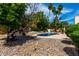 Spacious backyard with a pool, trees, and seating areas offering ample space for outdoor activities and relaxation at 4556 E Paradise Ln, Phoenix, AZ 85032