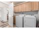 Functional laundry room with upper cabinets, countertop space, and a full-size washer and dryer at 4556 E Paradise Ln, Phoenix, AZ 85032