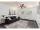 Bright living room with dark sofa, ceiling fan, and shuttered window at 4556 E Paradise Ln, Phoenix, AZ 85032