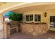 Covered outdoor kitchen with built-in grill and ample counter space at 4556 E Paradise Ln, Phoenix, AZ 85032