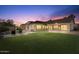 Beautiful twilight backyard featuring a swimming pool, expansive lawn, and covered patio at 4589 N 154Th Ave, Goodyear, AZ 85395