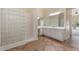 Bathroom featuring a glass block shower, double sink vanity, and tiled floor at 4589 N 154Th Ave, Goodyear, AZ 85395