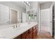 Bathroom with double sinks, large mirrors, and tiled flooring leading into the bedroom at 4589 N 154Th Ave, Goodyear, AZ 85395