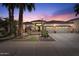 Twilight exterior view highlighting desert landscaping and a three-car garage at 4589 N 154Th Ave, Goodyear, AZ 85395