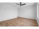 Minimalist bedroom featuring neutral walls, wood flooring, and contemporary ceiling fan at 4629 E Southern Ave, Phoenix, AZ 85042
