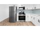 Modern kitchen with stainless steel appliances, white cabinets, and blue backsplash, creating a stylish cooking space at 4629 E Southern Ave, Phoenix, AZ 85042