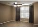 A cozy bedroom illuminated by natural light, complete with a ceiling fan and stylish curtains at 4747 E Narrowleaf Dr, Gilbert, AZ 85298