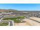 Aerial view showcases neighborhood park and playground amid residential area with mountain backdrop at 4811 W Hunter Trl, San Tan Valley, AZ 85144