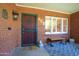 Welcoming front porch featuring a secure door, a bench and brick accent wall at 502 W Windsor Ave, Phoenix, AZ 85003