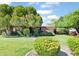 Charming single-story brick home with lush green lawn, mature trees, and colorful landscaping under a blue sky at 502 W Windsor Ave, Phoenix, AZ 85003