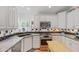 Well-lit kitchen with stainless steel appliances, dual sink, white cabinetry, and decorative tile backsplash at 502 W Windsor Ave, Phoenix, AZ 85003